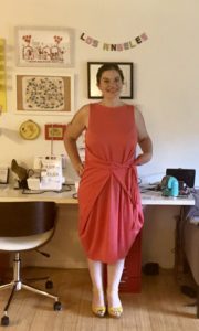 A woman in a coral-colored wrap dress