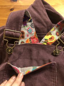 Detail of the overall bib and straps, showing the colorful elephant lining.
