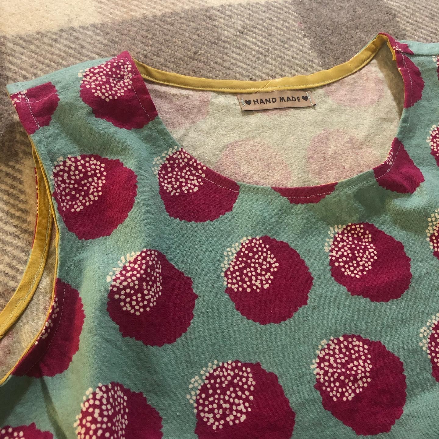 Detail of the blue and red tank, showing the yellow binding used to finish the neck and arms.